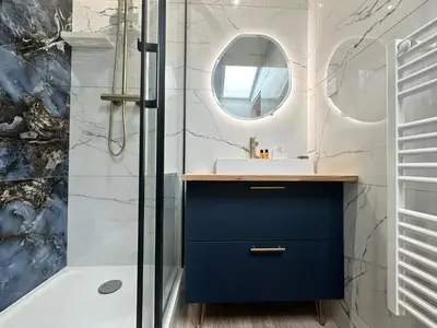 a bathroom with a blue vanity and a shower at Elegant mansardé-place du pin in Nice