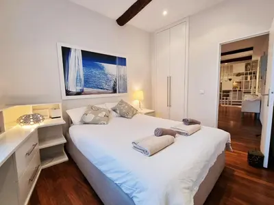 a white bedroom with a large white bed with a window at 