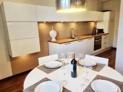 a kitchen with a table with glasses and a bottle of wine at 