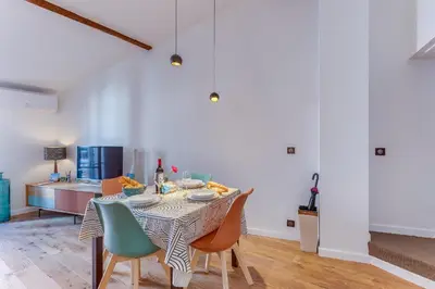 a dining room with a table and chairs and a kitchen at LA TREILLE AP4334 By Riviera Holiday Homes in Nice