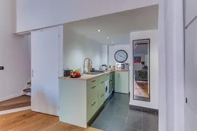 a kitchen with green cabinets and a clock on the wall at LA TREILLE AP4334 By Riviera Holiday Homes in Nice
