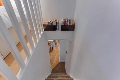 a hallway with stairs with a book shelf on the side at LA TREILLE AP4334 By Riviera Holiday Homes in Nice
