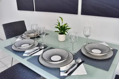 a dining table with plates and wine glasses on it at Bel appartement au cœur de Nice (2 chambres) in Nice