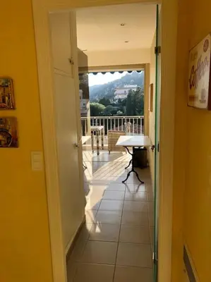 a hallway with a view of a balcony with a table at Appartement „Bellevue“ Villefranche-sur-Mer in Villefranche-sur-Mer