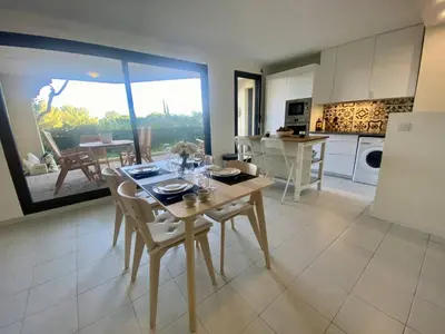 a kitchen and dining room with a table and chairs at Nice Ouest- 2P au Calme, Piscine, AC in Nice