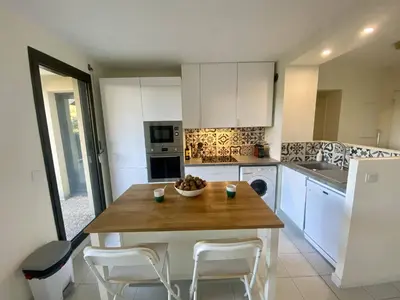 a kitchen with a table with a bowl of fruit on it at Nice Ouest- 2P au Calme, Piscine, AC in Nice