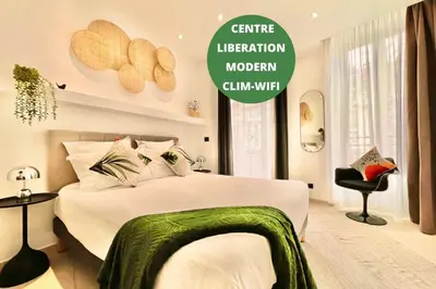 a bedroom with a bed with a green blanket on it at LIBERATION CENTER - PRIVATE Balcony - 24&7 RECEPTION - LUGGAGE STORAGE in Nice