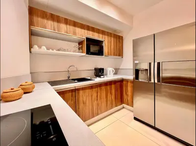 a kitchen with wooden cabinets and a stainless steel refrigerator at LIBERATION CENTER - PRIVATE Balcony - 24&7 RECEPTION - LUGGAGE STORAGE in Nice