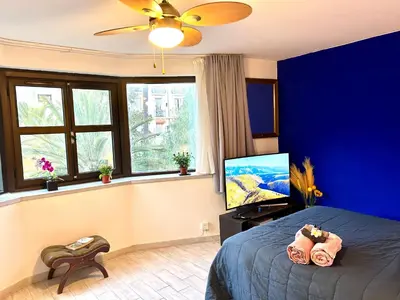 a blue bedroom with a bed and a window at SuperbeStudio in Nice - 450m of the sea- garden view in Nice