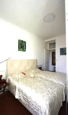 a bedroom with a large bed with a white bedspread at APPARTEMENT NICE le PORT in Nice