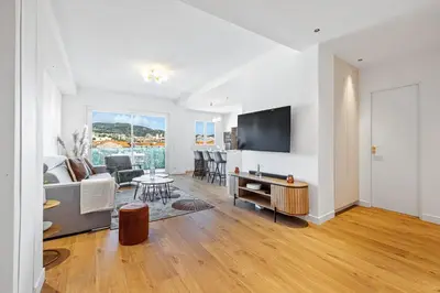 a living room with a couch and a tv and a table at Appartement Loulib I Electio in Nice