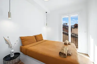 a bedroom with a bed and a large window at Appartement Loulib I Electio in Nice