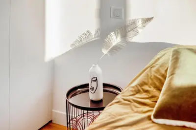 a vase sitting on a table next to a bed at Appartement Loulib I Electio in Nice