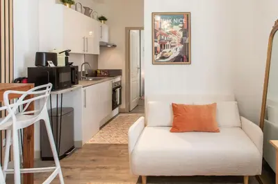 a living room with a white couch and a kitchen at L46 2P Port, 2min du Cap et 5 du port/ CLIM & WIFI in Nice