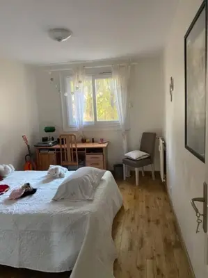 a bedroom with a bed and a desk and window at Angele Stephen in Nice
