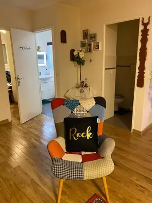 a living room with a chair with a pillow on it at Angele Stephen in Nice