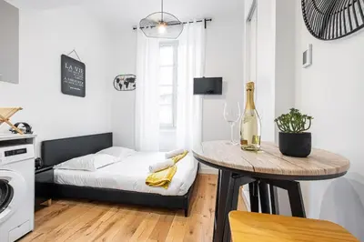 a small apartment with a bed and a table with a bottle of wine at Charming City Center Studio 108 in Nice