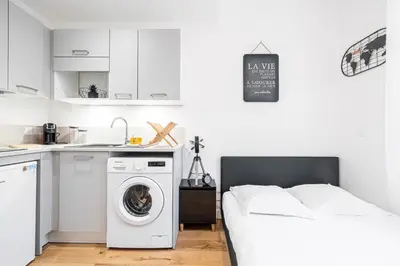 a white bedroom with a washing machine and a sink at Charming City Center Studio 108 in Nice