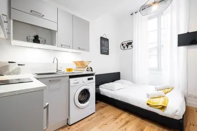 a small white kitchen with a washer and dryer at Charming City Center Studio 108 in Nice