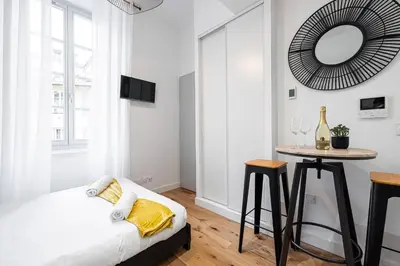 a bedroom with a bed and a table with a mirror at Charming City Center Studio 108 in Nice