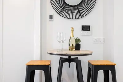 a table with a bottle of wine and two stools at Charming City Center Studio 108 in Nice