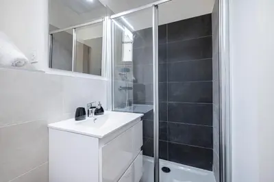a white bathroom with a shower and a sink at Charming City Center Studio 108 in Nice