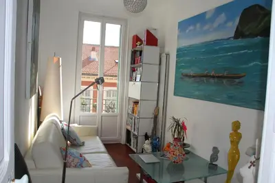 a living room with a white couch and a book shelf at APPARTEMENT NICE le PORT in Nice