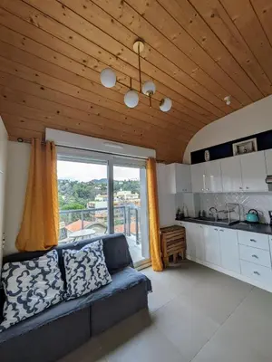 a living room with a couch and a large window at Studio calme avec vue dégagée in Nice