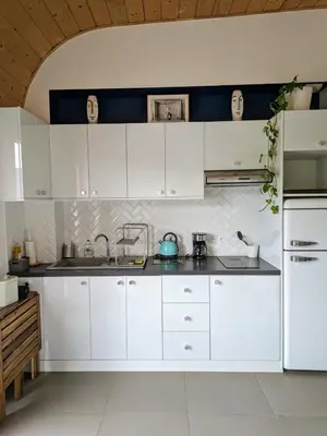 a white kitchen with white cabinets and appliances at Studio calme avec vue dégagée in Nice