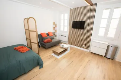 a bedroom with a bed and a couch and a television at Cozy studio in Villefranche-sur-Mer in Villefranche-sur-Mer