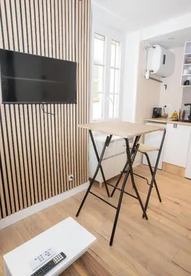 a desk with a television and a table in a room at Cozy studio in Villefranche-sur-Mer in Villefranche-sur-Mer