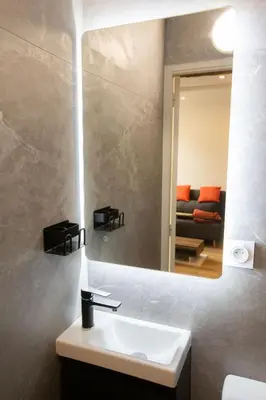 a bathroom with a sink and a mirror and a couch at Cozy studio in Villefranche-sur-Mer in Villefranche-sur-Mer