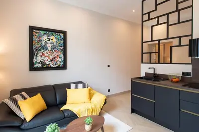 a living room with a couch and a painting on the wall at L37 F1 Central 2 min de la mer Balcon & CLIM in Nice