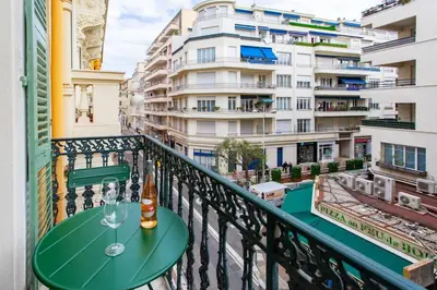 a table on a balcony with a bottle and glasses at L37 F1 Central 2 min de la mer Balcon & CLIM in Nice