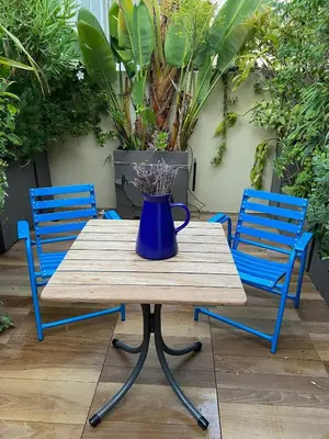 a blue vase sitting on a wooden table with two chairs at Exceptional Terrace in Center of Nice in Nice