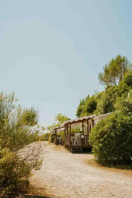a train is parked on a dirt road at Camping VAL FLEURI ATC Cagnes-Sur-Mer in Cagnes-sur-Mer