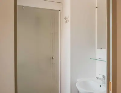 a white bathroom with a shower and a sink at Camping VAL FLEURI ATC Cagnes-Sur-Mer in Cagnes-sur-Mer