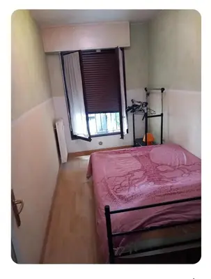 a bedroom with a pink bed and a window at Les carlins in Nice