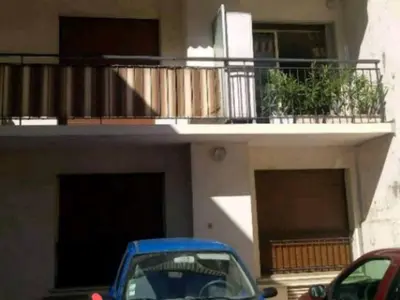 a building with a balcony and a blue car parked in front at Les carlins in Nice