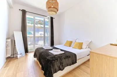 a bedroom with a bed and a large window at CENTRE VILLE-GRAND APPARTEMENT DE 50 M2 - COSY AVEC TERRASSE -Wifi in Nice