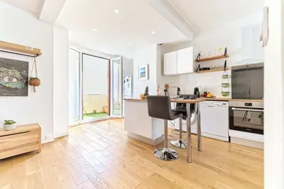 a kitchen with white cabinets and a table with a chair at CENTRE VILLE-GRAND APPARTEMENT DE 50 M2 - COSY AVEC TERRASSE -Wifi in Nice