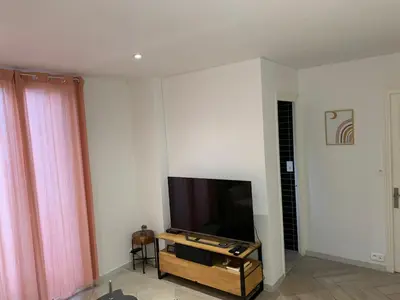 a living room with a flat screen tv on a wall at Charmant Appartement à 5 minutes de la plage in Nice