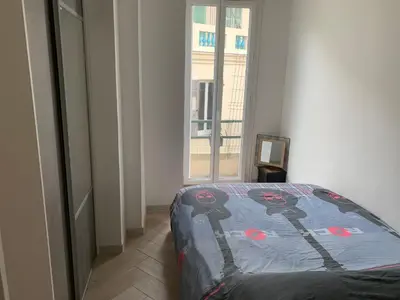 a bedroom with a bed in a room with a window at Charmant Appartement à 5 minutes de la plage in Nice