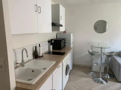 a small kitchen with a sink and a refrigerator at Charmant Appartement à 5 minutes de la plage in Nice