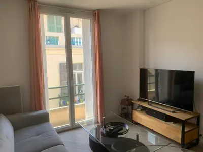 a living room with a couch and a television at Charmant Appartement à 5 minutes de la plage in Nice