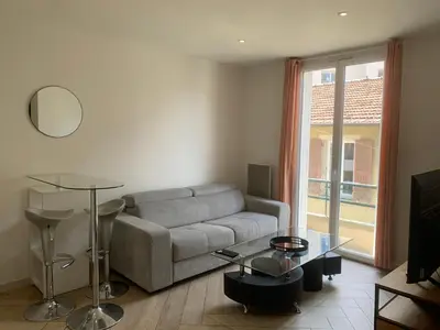 a living room with a couch and a table at Charmant Appartement à 5 minutes de la plage in Nice