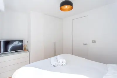 a white bedroom with a bed and a tv at #11 Alex suite terrace parking AC 2 BDR 5mins to sea in Saint-Jean-Cap-Ferrat