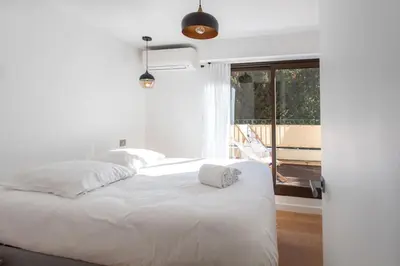 a bedroom with a white bed and a balcony at #11 Alex suite terrace parking AC 2 BDR 5mins to sea in Saint-Jean-Cap-Ferrat