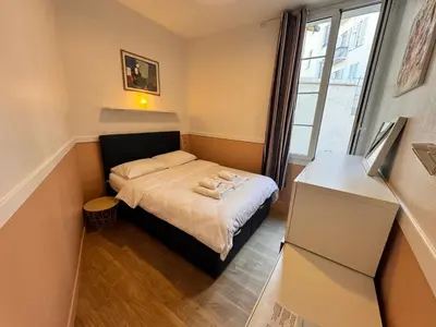 a small bedroom with a bed and a window at Peaceful Flat w WiFi Very Close to Pl Massena Refurbished in Nice
