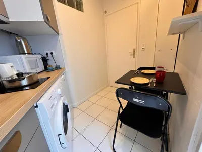 a small kitchen with a table and a washing machine at Peaceful Flat w WiFi Very Close to Pl Massena Refurbished in Nice